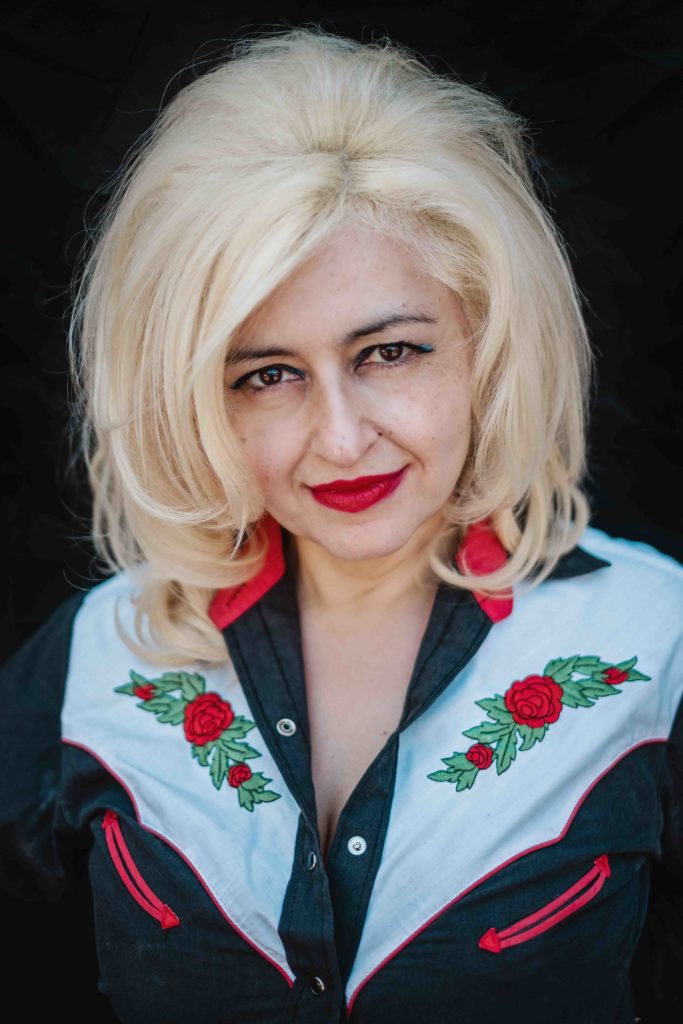 Melbourne-based concert promoter Mary Mihelakos wears a cowboy shirt with embroidered red roses that match her bright lipstick and blonde bouffant