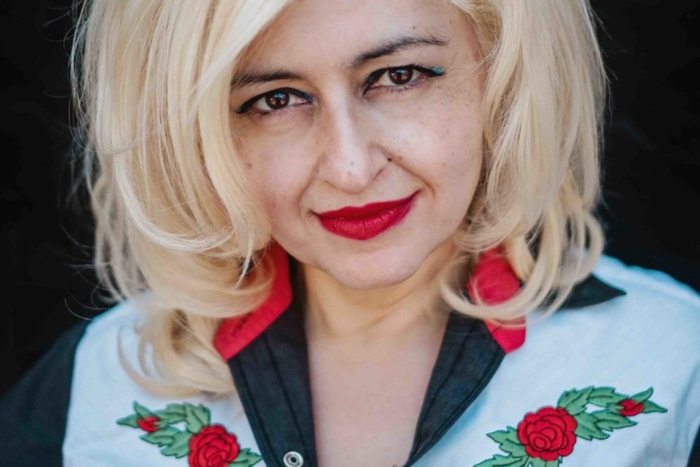 Melbourne-based concert promoter Mary Mihelakos wears a cowboy shirt with embroidered red roses that match her bright lipstick and blonde bouffant